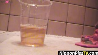 NipponPissTV.com - Kinky Japanese babe plays with her cat after peeing in cups indoor