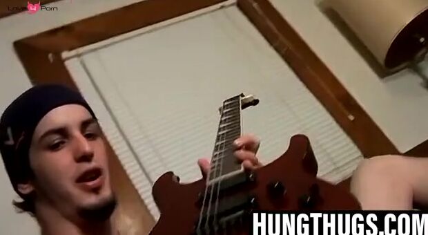 Guitar player strums while stroking hairy cock