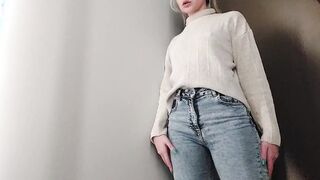 A young women with elastic jugs checks out bras into the fitting room