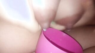 Young cougar pours milk from breasts inside a cup