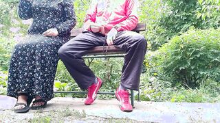 Cutie cougar jerks off a long penis inside a glass into the park on a bench