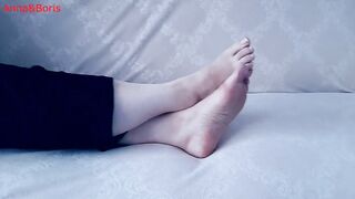 For comfort, Anna sits barefoot on the sofa - two