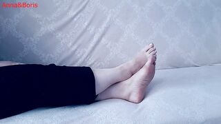 For comfort, Anna sits barefoot on the sofa - two