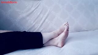 For comfort, Anna sits barefoot on the sofa - two