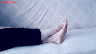 For comfort, Anna sits barefoot on the sofa - two