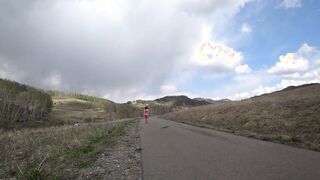 Older MILF with nude charms walks on a outdoors road