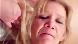Blonde granny is taking a cumshot on her eyes