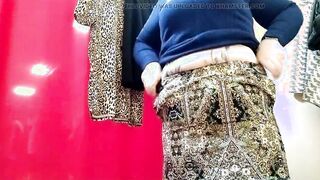 Curvy lady with a long booty tries on clothes into a shopping mall fitting room