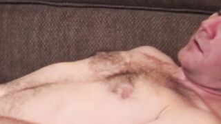 Hairy dude strips down and jerks off his dick until he cums
