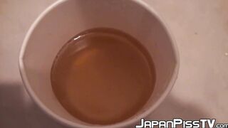 Japanese cutie fills a cup up with her pee and records it