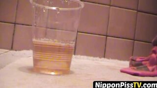 Delightful Japanese chick sits on the latrine and pees in a cup