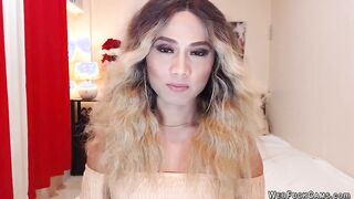 Asain blonde TS wanks cock in chair in front of webcam
