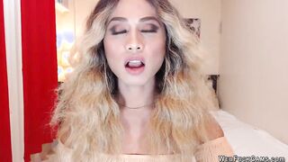 Asain blonde TS wanks cock in chair in front of webcam