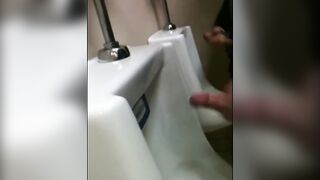 two slim dicks getting wanked at the urinals