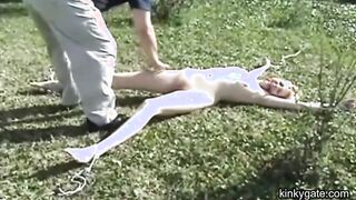 My blonde slut lying tied up on the lawn