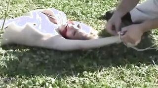 My blonde slut lying tied up on the lawn