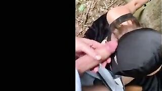 Soumise cagoulee et attachee suce son maitre dans les bois