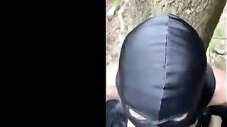 Soumise cagoulee et attachee suce son maitre dans les bois