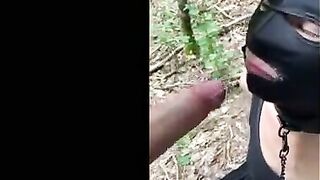 Soumise cagoulee et attachee suce son maitre dans les bois
